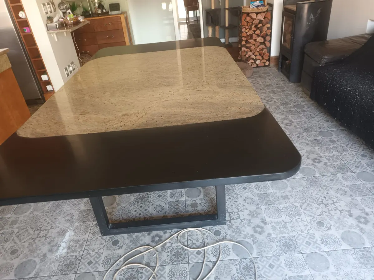 Restored granite table top on a black base in an open-plan living area