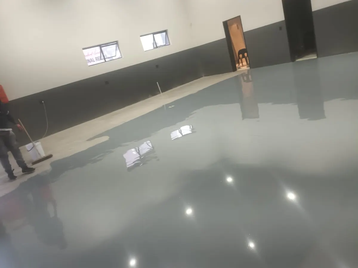Grey self-levelling epoxy floor with a high gloss in an empty commercial unit
