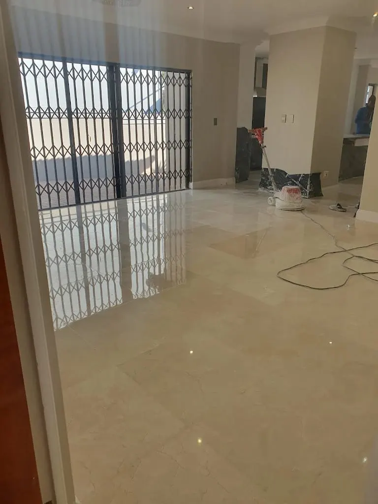 Marble floor with a mirror shine in an entrance area, polishing machine in the background