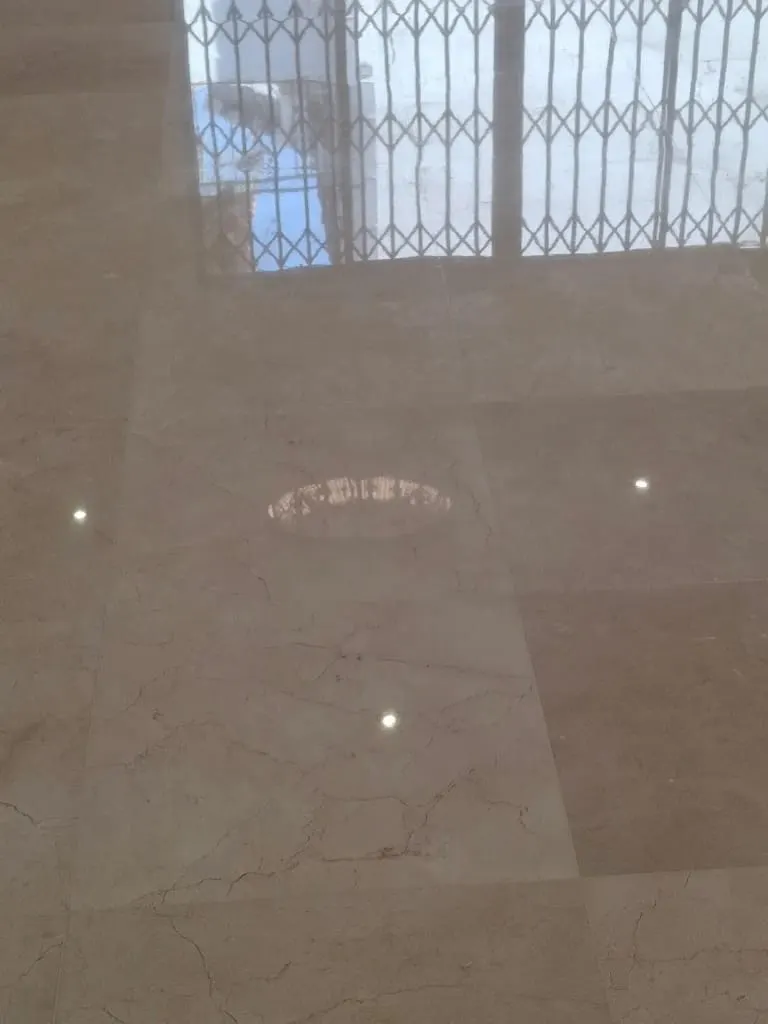 Close-up of polished cream marble tiles reflecting a window