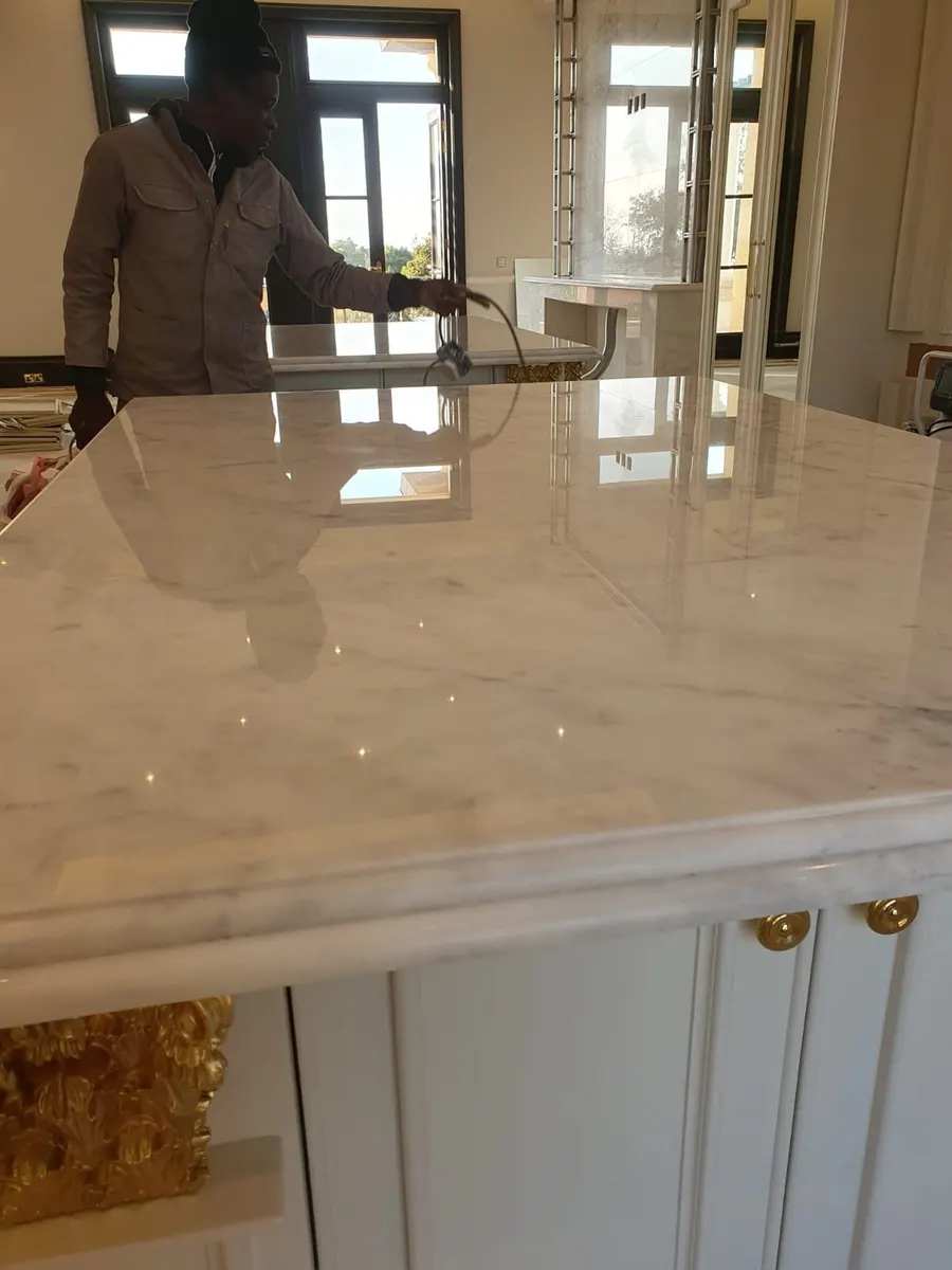 White marble kitchen island being polished, with a high shine on the top