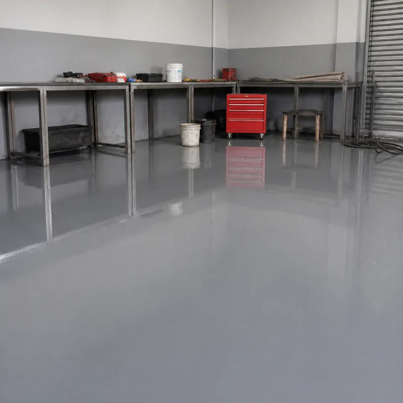 Finished mid-grey gloss epoxy workshop floor with workbenches
